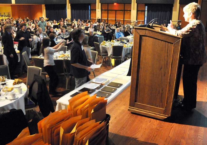 When almost 400 students and teachers fill the Kent State ballroom for the awards ceremony, the result will always be loud! OSMA executive director Candace Perkins Bowen announces advance contest category winners while names flash on the screen. (photo by John Bowen)