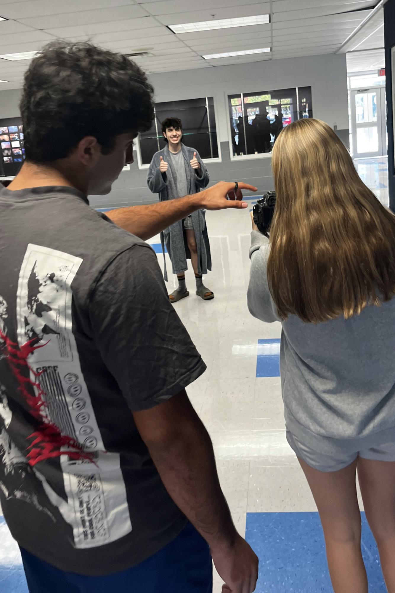 Junior Aryan Amirtabar helps senior Sydney Cottrill capture a photo during Spirit Week at Granville High School. Returning yearbook staff members paired up with new staff members early in the year to help them learn photography skills. 
